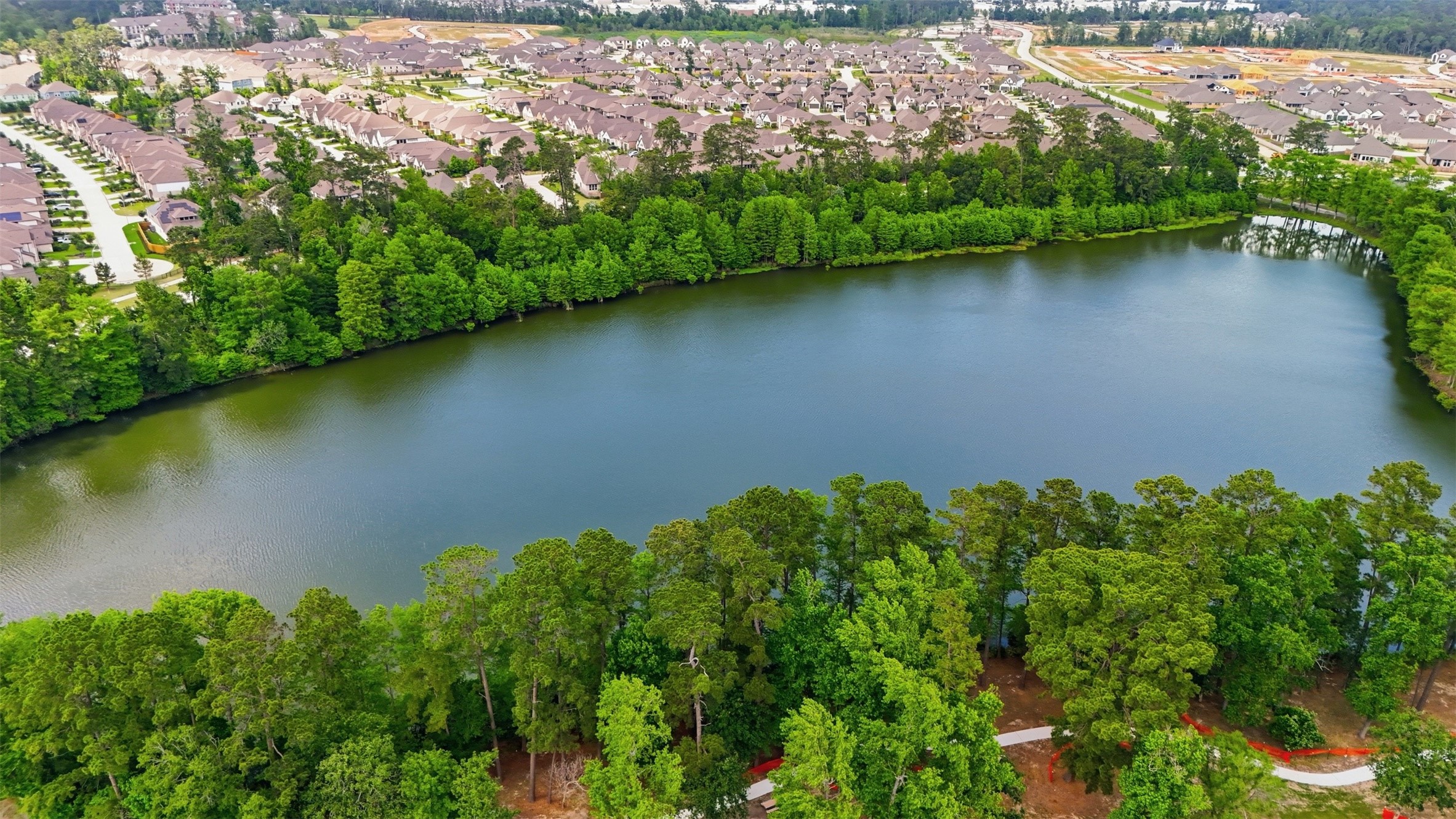 416 Venado View Court Conroe, TX 77304 - Photo 33 of 34 Beautiful community lake surrounded by mature trees and peaceful walking trails offering a tranquil natural setting just moments from home.