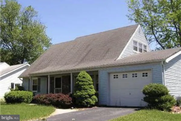 a view of a house with a garage and plants