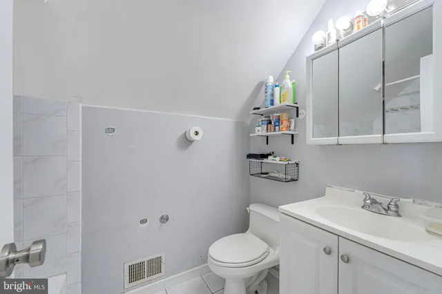 a bathroom with a sink vanity mirror and toilet