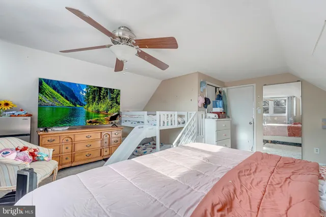 a bedroom with a bed dresser and a flat tv screen