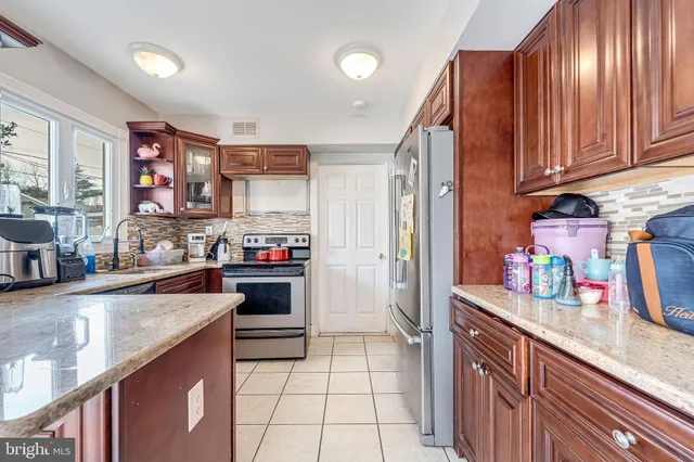 a kitchen with stainless steel appliances granite countertop a refrigerator and a sink