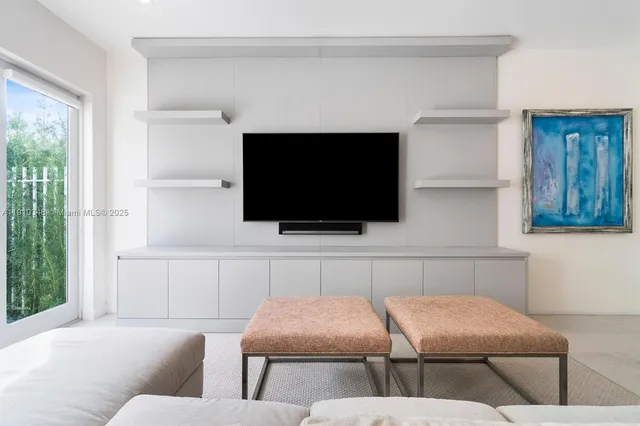 a kitchen with stainless steel appliances granite countertop a sink a stove a refrigerator and white cabinets with wooden floor