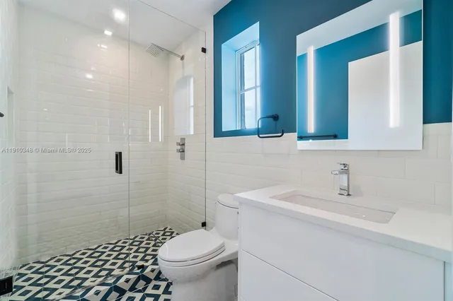 a bathroom with a white tub shower and sink