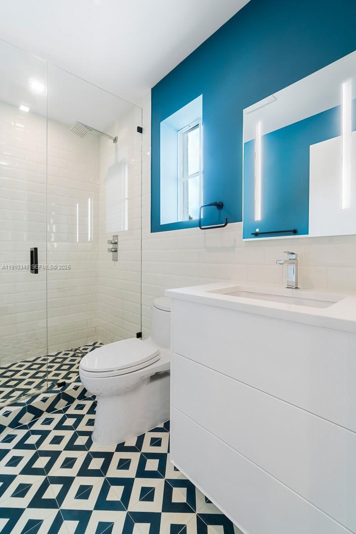 19941 Northeast 36th Place Aventura, FL 33180 - Photo 31 of 39 a bathroom with a sink a toilet a mirror and shower