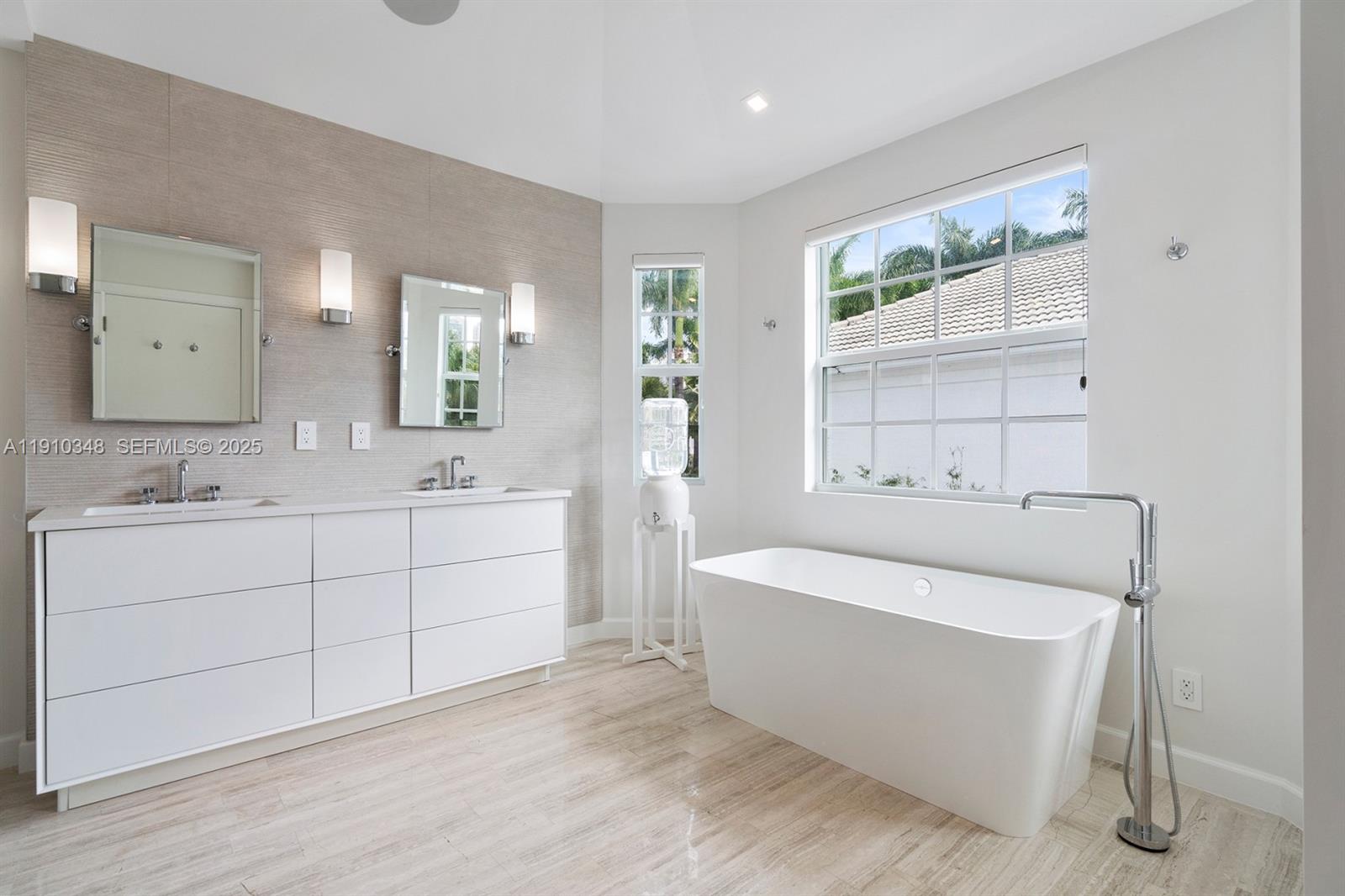 19941 Northeast 36th Place Aventura, FL 33180 - Photo 33 of 39 a spacious bathroom with a double vanity sink a mirror and a bathtub