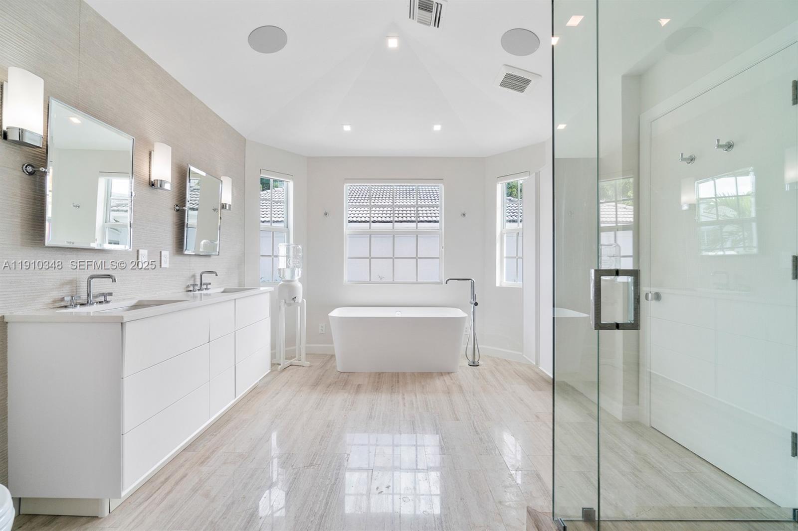 19941 Northeast 36th Place Aventura, FL 33180 - Photo 34 of 39 a large white bathroom with a double vanity sink a mirror and a bathtub