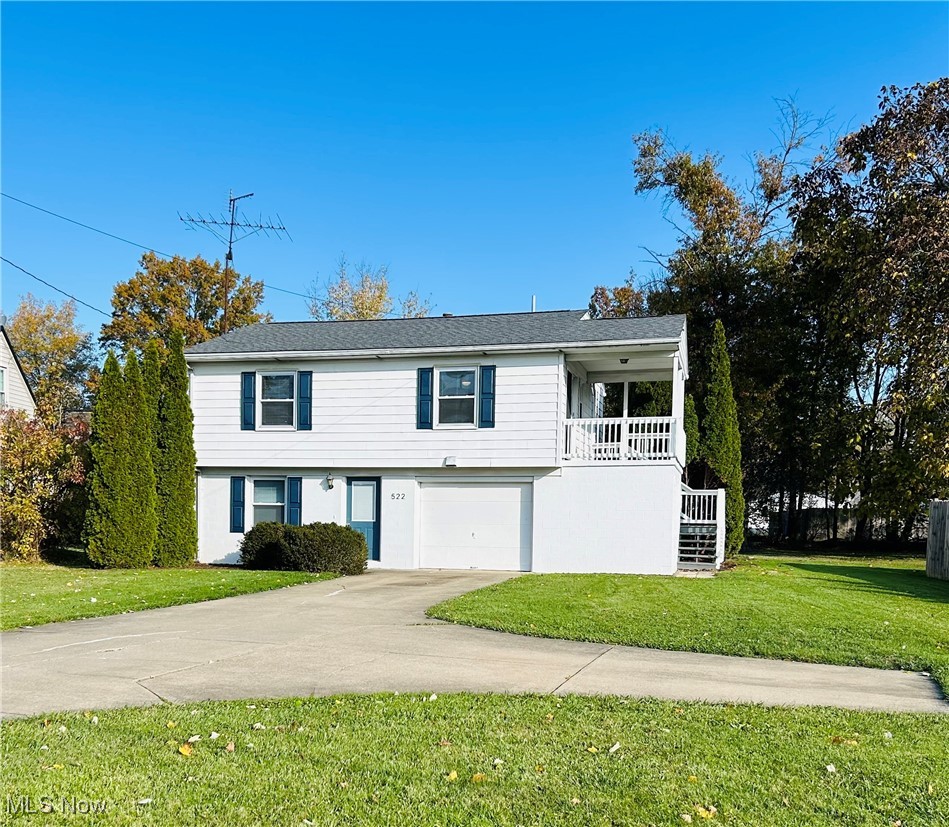 522 State Road Northwest Warren, OH 44483 - Photo 1 of 29 View of front of property featuring a front yard, stairway, concrete driveway, and a garage
