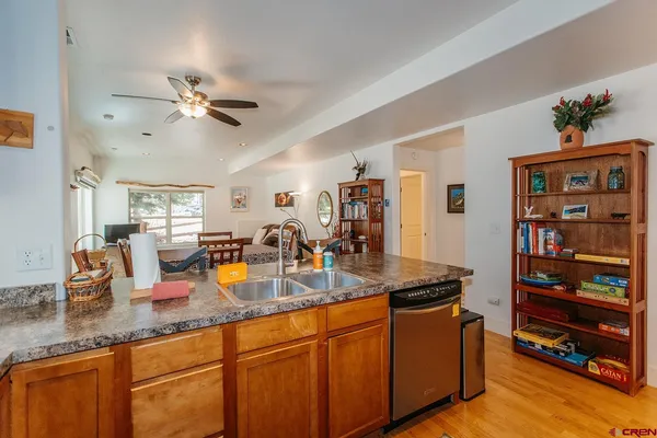 a kitchen with granite countertop a sink a stove and cabinets