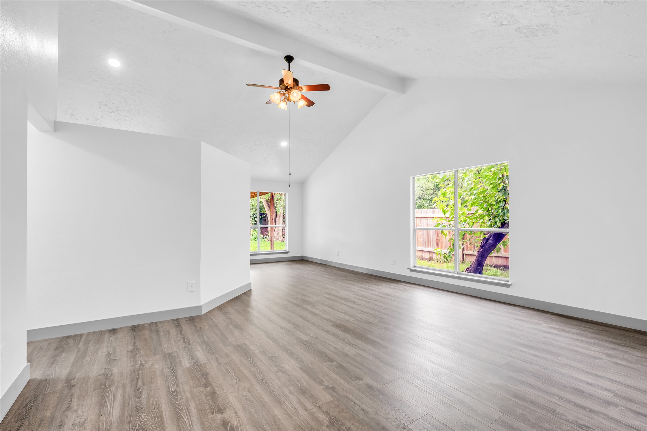 4631 Enchanted Rock Lane Spring, TX 77388 - Photo 7 of 12 A vaulted ceiling living area with wood-look flooring and naturally illuminated window views.