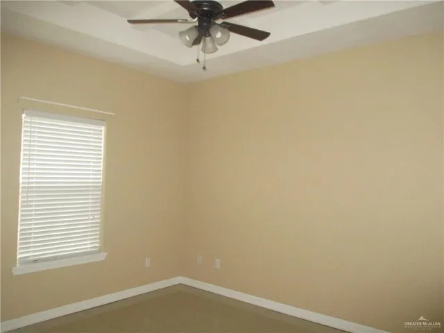 an empty room with a window and a fan