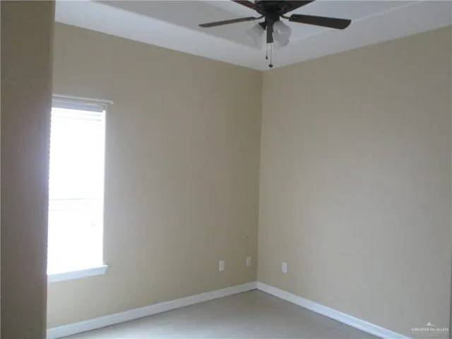 an empty room with a window and a fan