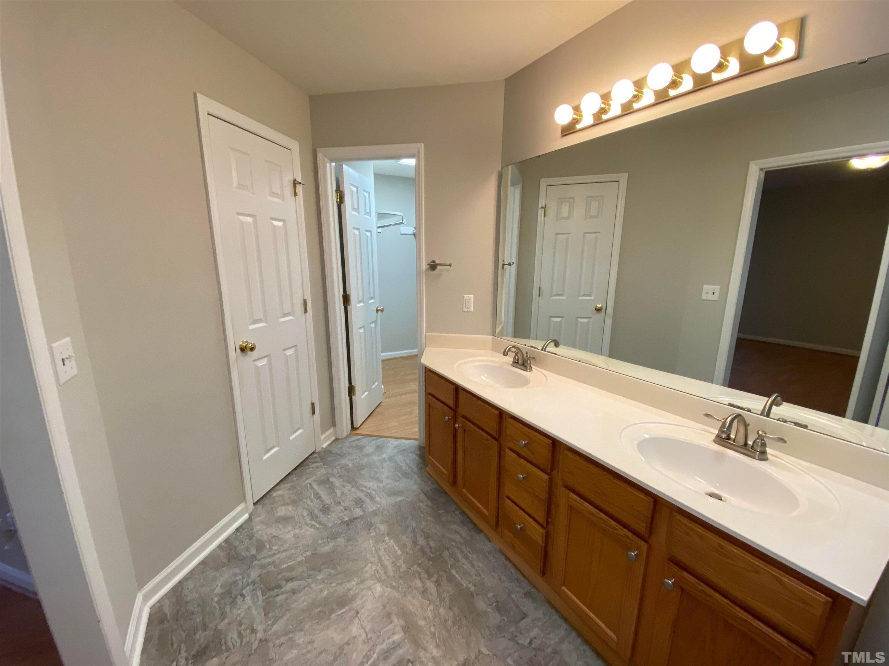 2413 Wellington Ridge Loop, Unit 2413 Cary, NC 27518 - Photo 23 of 30 a spacious bathroom with double vanity and mirrors