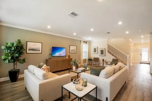 a living room with furniture and a wooden floor