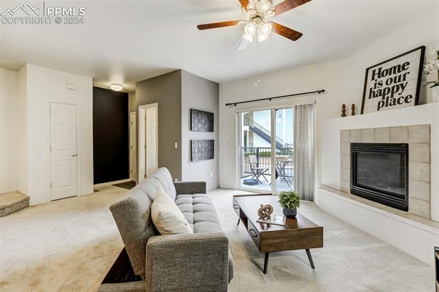 2002 Legacy Ridge View, Unit 112 Colorado Springs, CO 80910 - Photo 11 of 37 Bright living room featuring a gas fireplace, ceiling fan w/walk-out access to the patio.