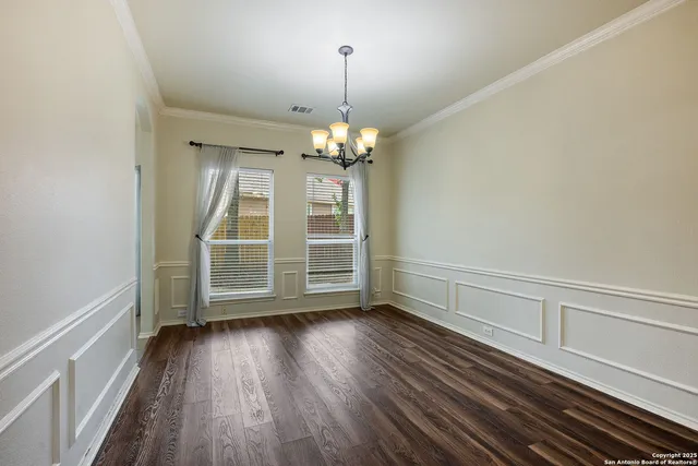 a view of wooden floor chandelier and window in a room