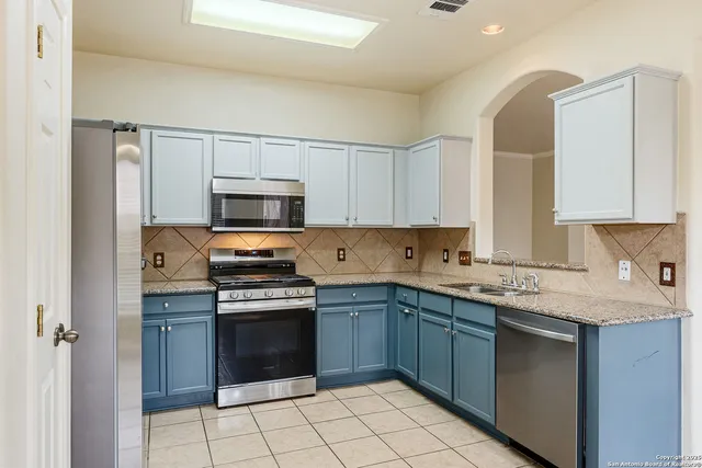 a kitchen with granite countertop a stove sink and cabinets