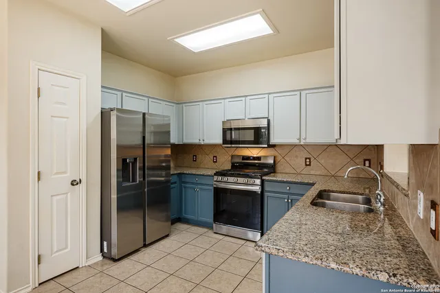 a kitchen with stainless steel appliances granite countertop a refrigerator stove and sink