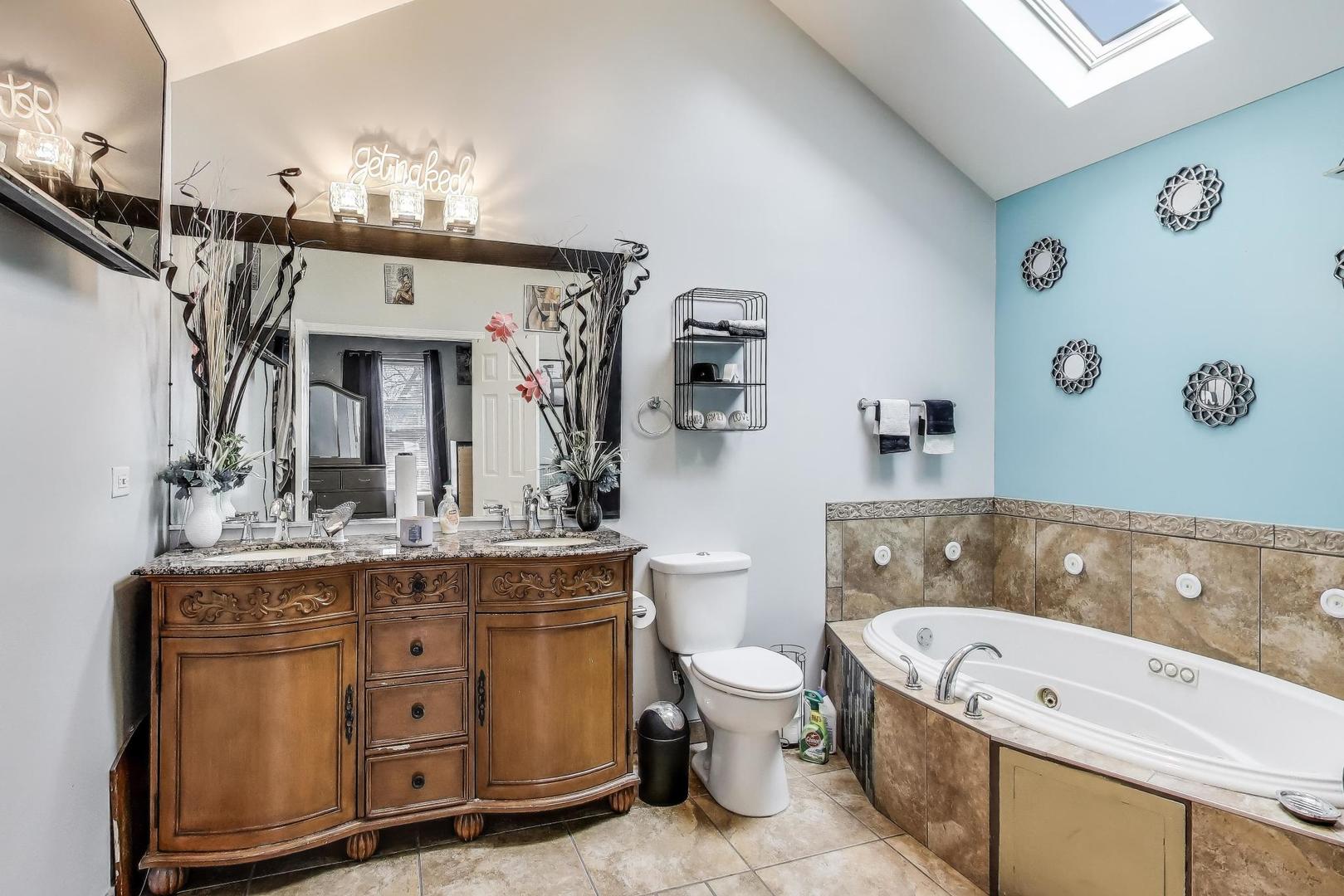 8618 South Morgan Street Chicago, IL 60620 - Photo 11 of 27 a spacious bathroom with a granite countertop tub sink and mirror