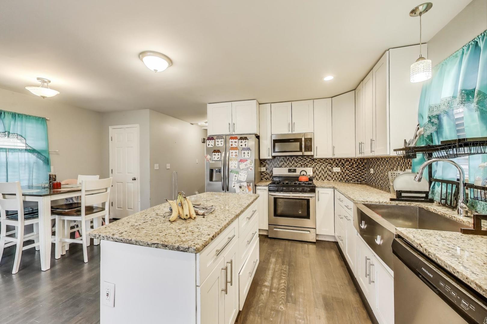 8618 South Morgan Street Chicago, IL 60620 - Photo 5 of 27 a kitchen with stainless steel appliances granite countertop a stove oven a sink dishwasher and a refrigerator with wooden floor