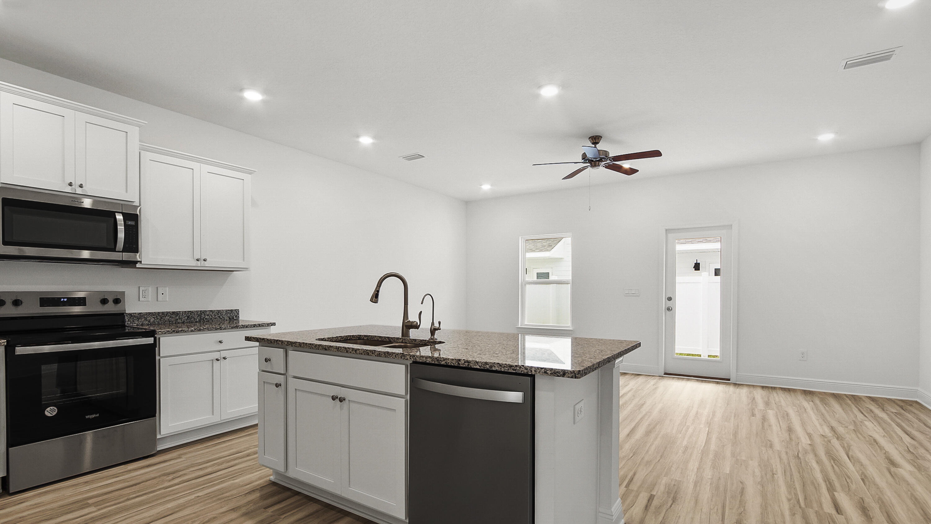 51 Phoenix Street Santa Rosa Beach, FL 32459 - Photo 6 of 34 a kitchen with a sink dishwasher a stove and white cabinets with wooden floor