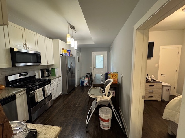 1431 North Springfield Avenue, Unit 2 Chicago, IL 60651 - Photo 8 of 19 a living room with furniture a flat screen tv and a refrigerator