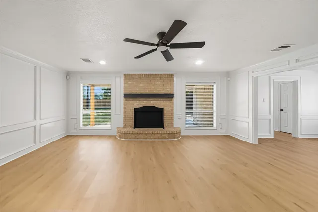 a view of empty room with wooden floor and fireplace