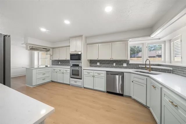 a kitchen with white cabinets and white appliances