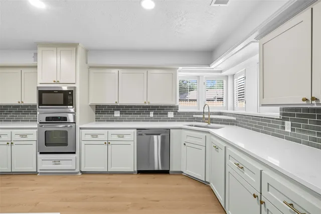 a white kitchen with granite countertop white cabinets and white appliances