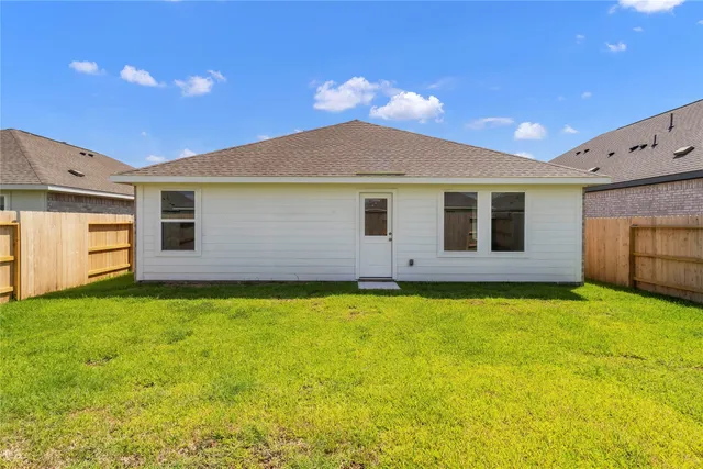 a view of a yard with a large tree and a wooden fence