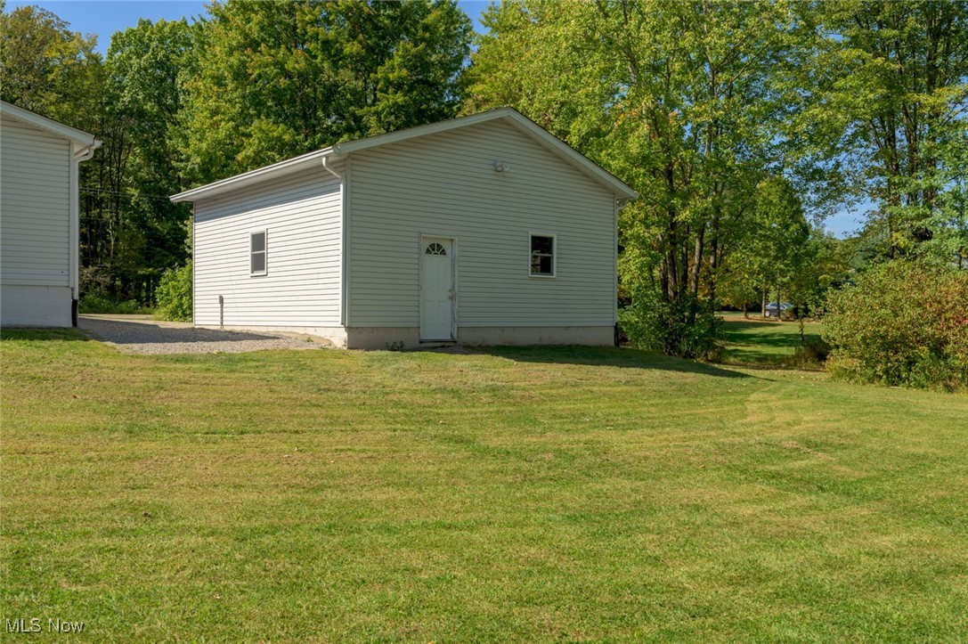 6600 Peck Road Ravenna, OH 44266 - Photo 38 of 50 Rear view of house featuring a yard and view of scattered trees