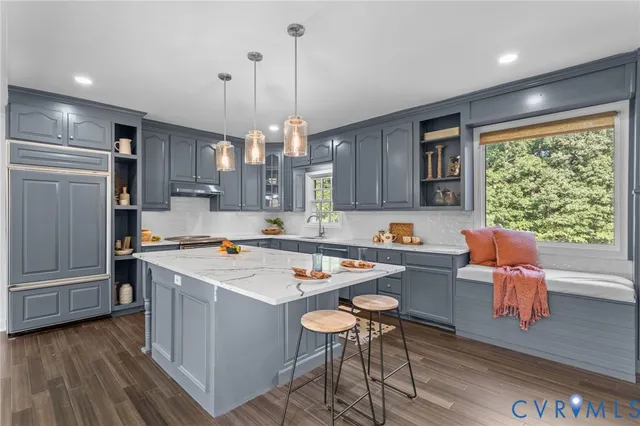 a kitchen with a table chairs refrigerator and wooden floor