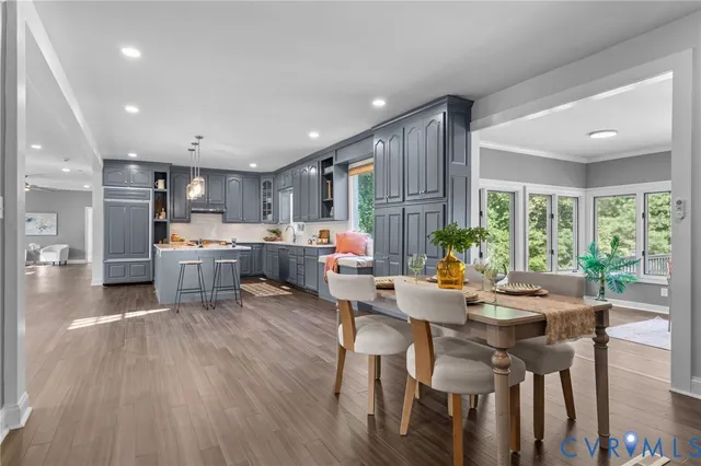 a living room with stainless steel appliances kitchen island granite countertop furniture and a wooden floor