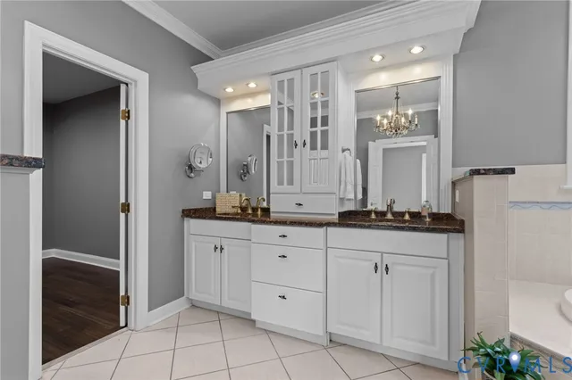 a bathroom with a granite countertop sink two mirror and a bathtub