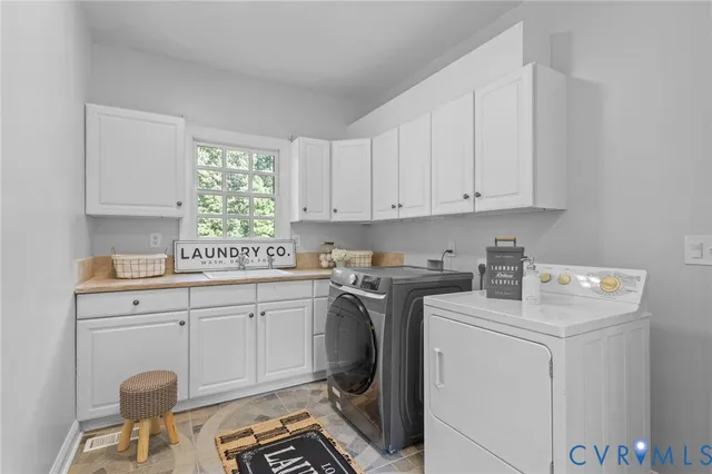 a utility room with sink dryer and washer