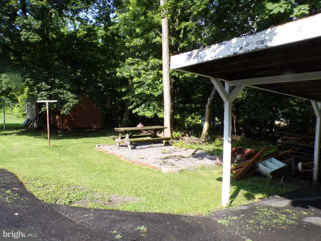 a view of a backyard with table and chairs under an umbrella