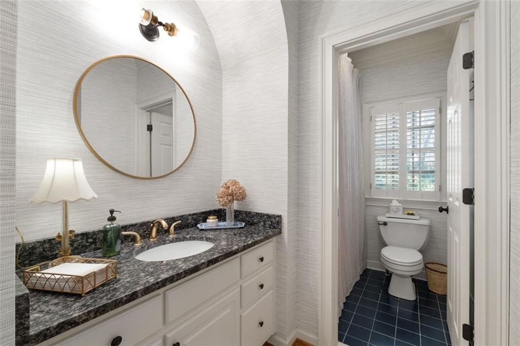 310 Glen Hampton Place Alpharetta, GA 30004 - Photo 13 of 61 a bathroom with a granite countertop toilet a sink and a mirror