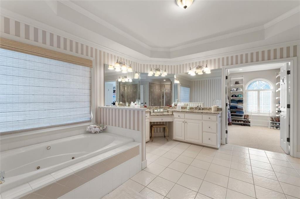 310 Glen Hampton Place Alpharetta, GA 30004 - Photo 17 of 61 a bathroom with a tub a sink and mirrors