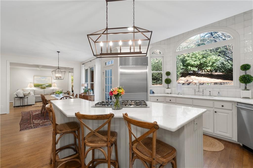 310 Glen Hampton Place Alpharetta, GA 30004 - Photo 5 of 61 a kitchen with stainless steel appliances a dining table chairs and wooden floor