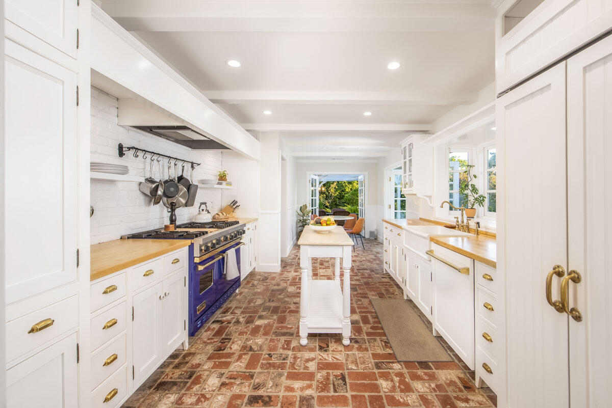 223 Rametto Road Santa Barbara, CA 93108 - Photo 18 of 35 a large white kitchen with granite countertop a sink a stove a chimney wooden floor and a dining table