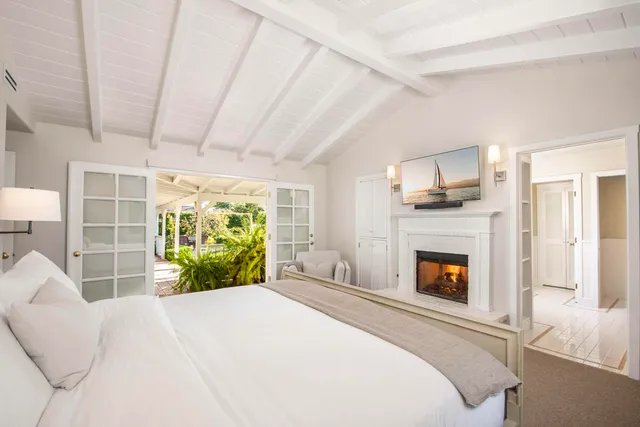 a bedroom with a bed a fireplace and a large window