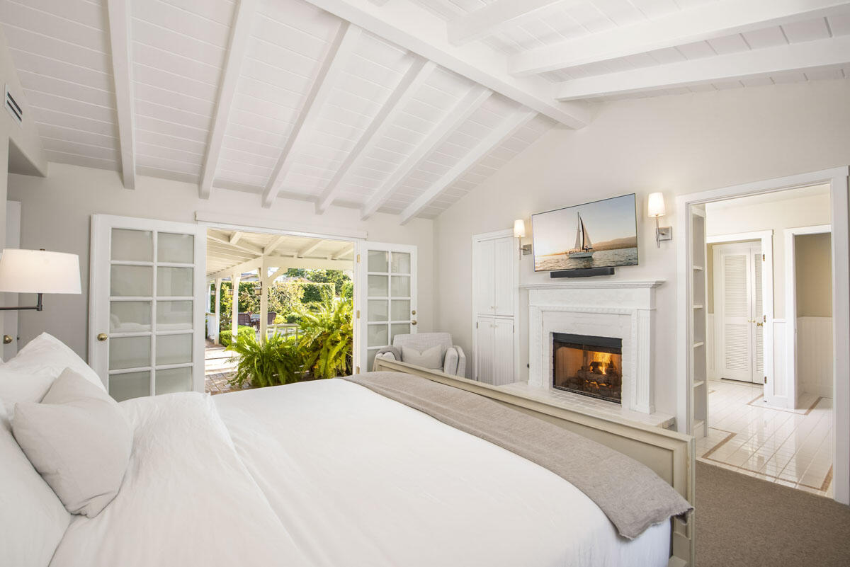 223 Rametto Road Santa Barbara, CA 93108 - Photo 22 of 35 a bedroom with a bed a fireplace and a large window