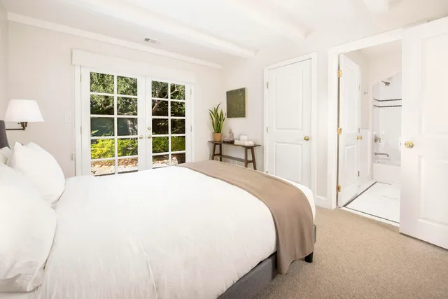 a bedroom with a bed and a large window