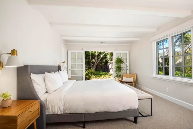 a bed sitting in a bedroom next to a window