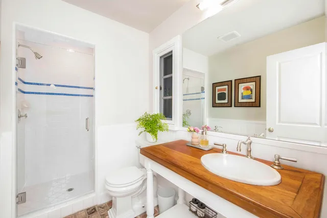 a bathroom with a granite countertop sink toilet and shower