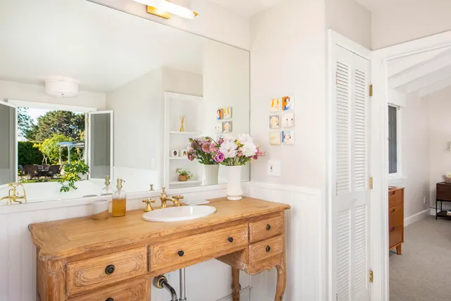 a bathroom with a granite countertop sink a large mirror and a shower