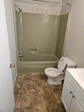 a bathroom with a toilet and a shower