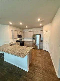 a kitchen with stainless steel appliances granite countertop a sink a stove and a refrigerator