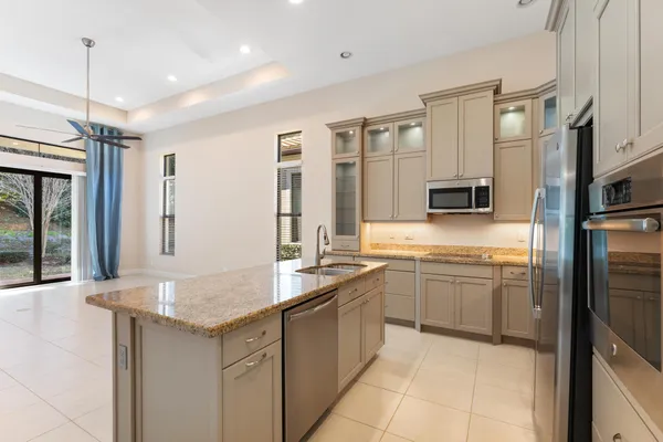 a kitchen with stainless steel appliances granite countertop a sink and dishwasher a refrigerator with wooden floor