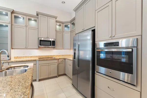 a kitchen with stainless steel appliances granite countertop a refrigerator and a sink