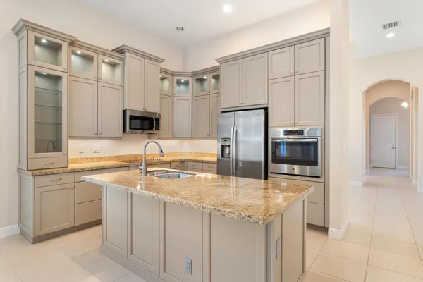 a kitchen with stainless steel appliances granite countertop a sink a stove and refrigerator